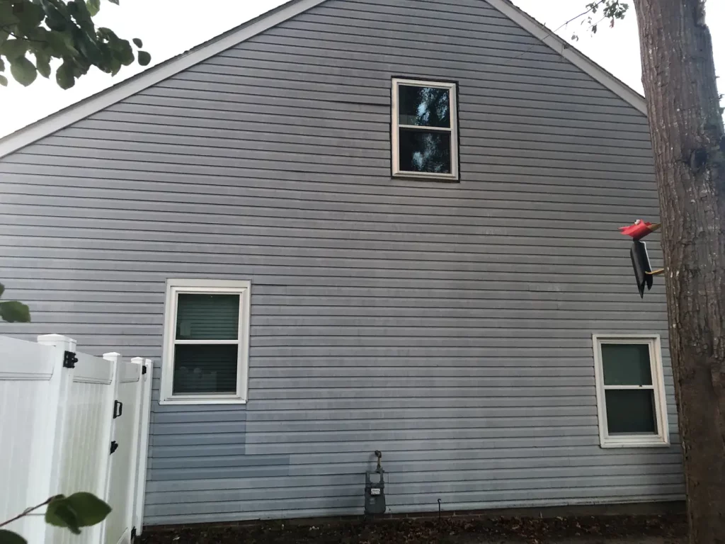 House with new windows, trim, siding, and gutter protection